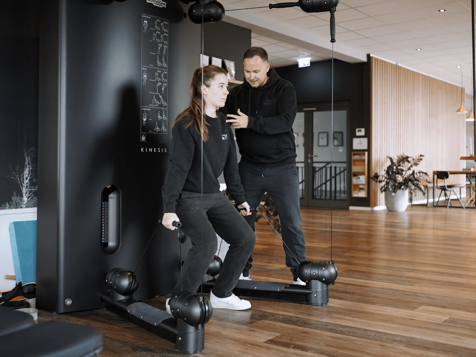 Ein INJOY Trainer unterstützt ein INJOY Mitglied bei der Bewegungsausführung.
