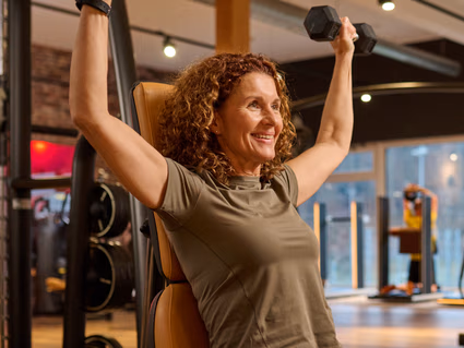 Ein INJOY Trainer unterstützt ein INJOY Mitglied bei der Bewegungsausführung.