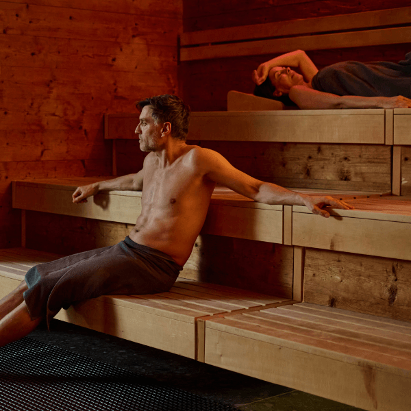 Zwei INJOY Mitglieder entspannen in der Sauna eines INJOY Fitnessstudios.