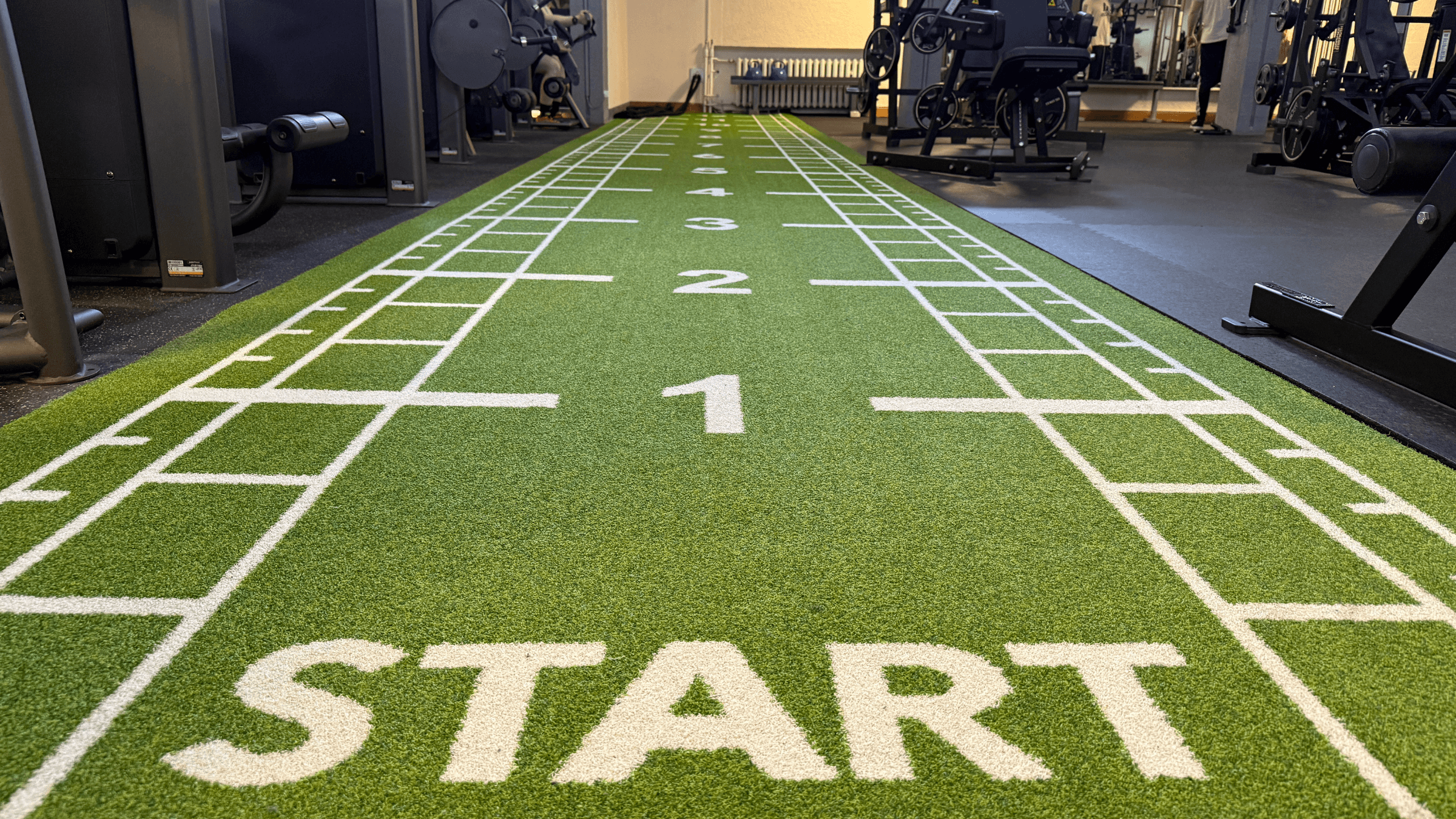 Eine grüne Kunstrasenmatte für Sprints und Übungen im INJOY Fitnessstudio Reichenbach.
