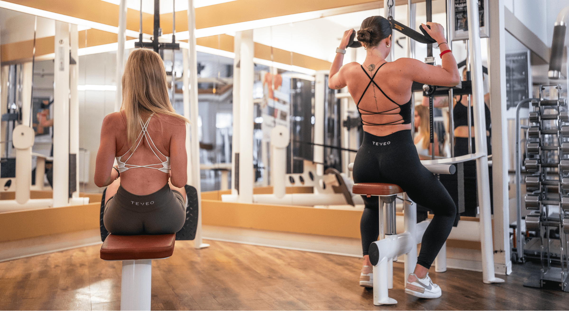 Zwei Frauen trainieren an Rück-Trainingsgeräten im INJOY Fitnessstudio Weida.