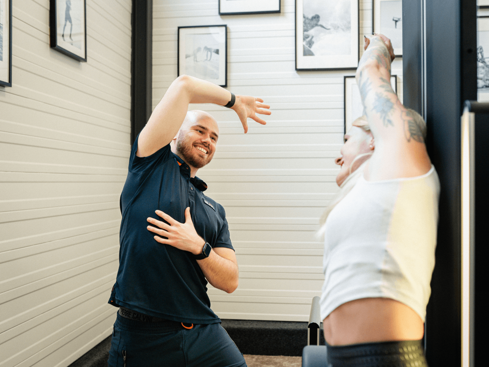 Ein Trainer zeigt einer Frau eine Dehnübung am Dehngerät im INJOY Fitnessstudio Soest