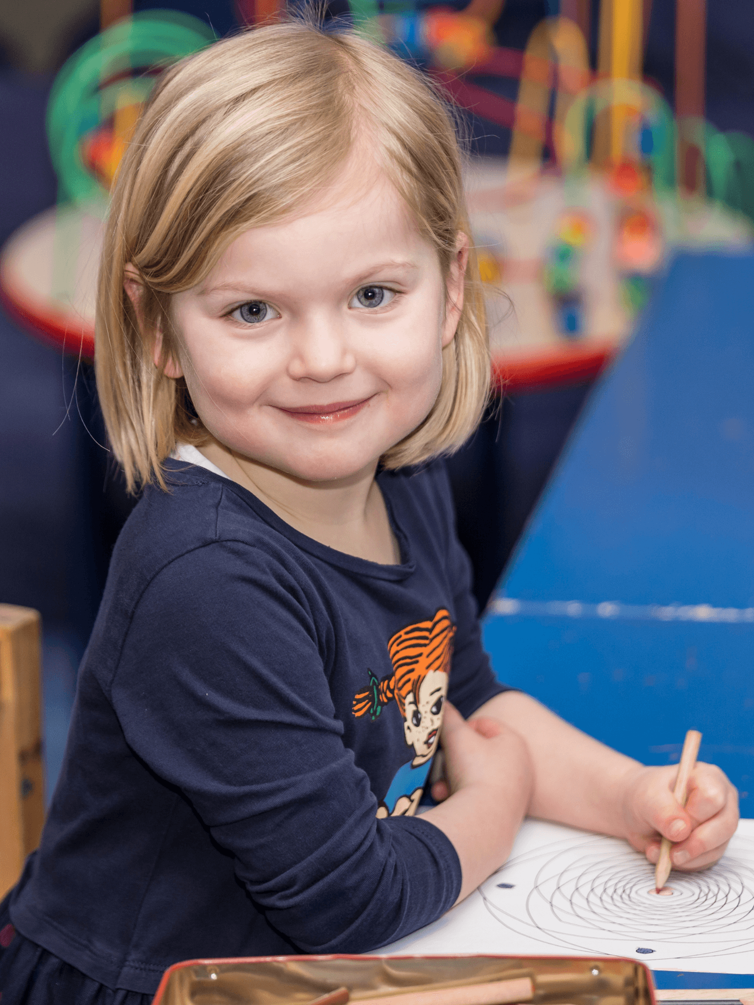 Ein fröhliches Kind malt in der Kinderbetreuung des INJOY Fitnessstudios in Hagen.