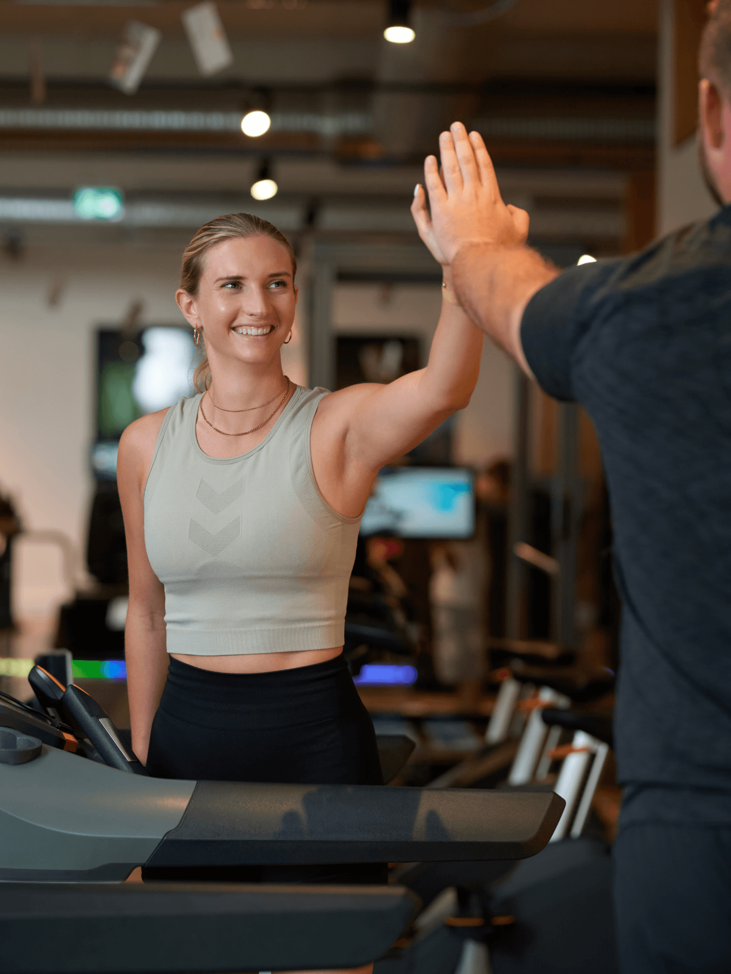 Ein INJOY Mitglied gibt einem INJOY Trainer ein High Five im INJOY Fitnessstudio.