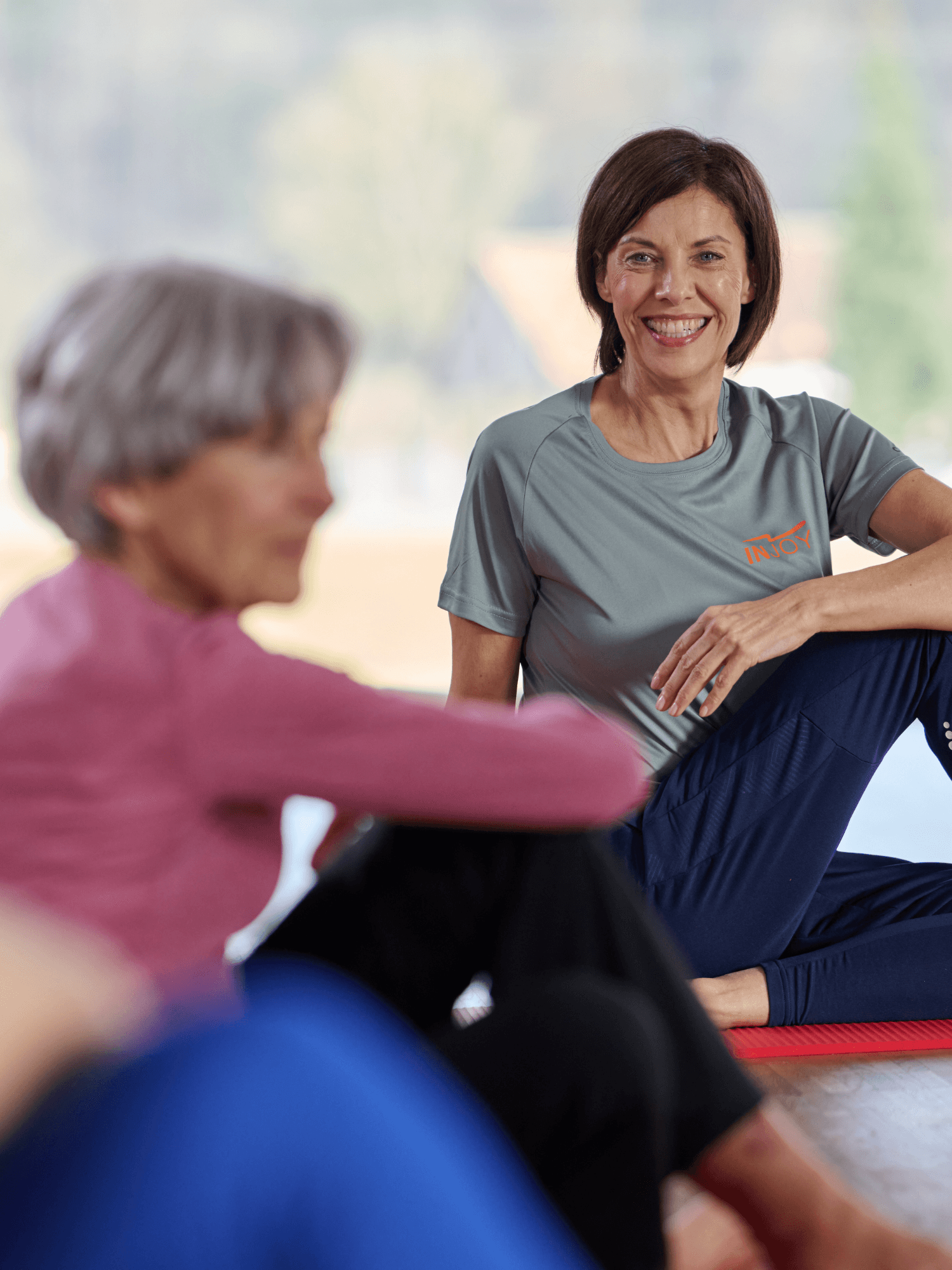 Eine INJOY Trainerin gibt einen Kurs für Mitglieder mit gesundheitlichen Beschwerden.