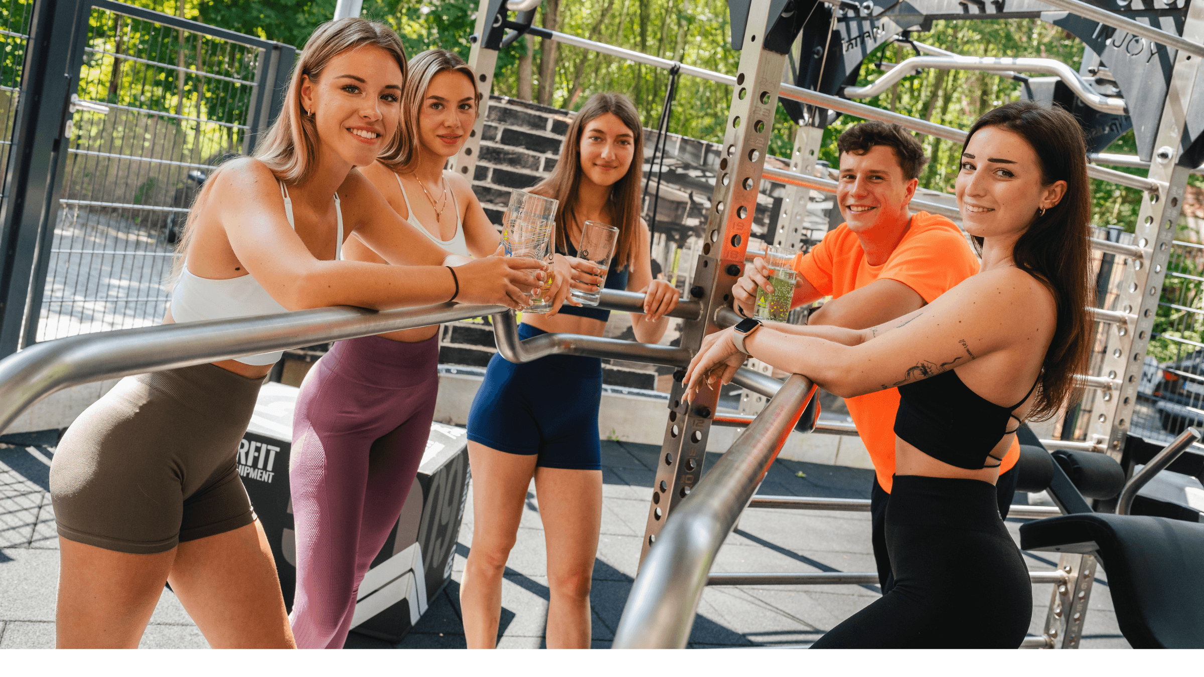 Drei Frauen und ein Mann stehen an einem Trainings-Tower im INJOY Fitnessstudio Weida und schauen in die Kamera.