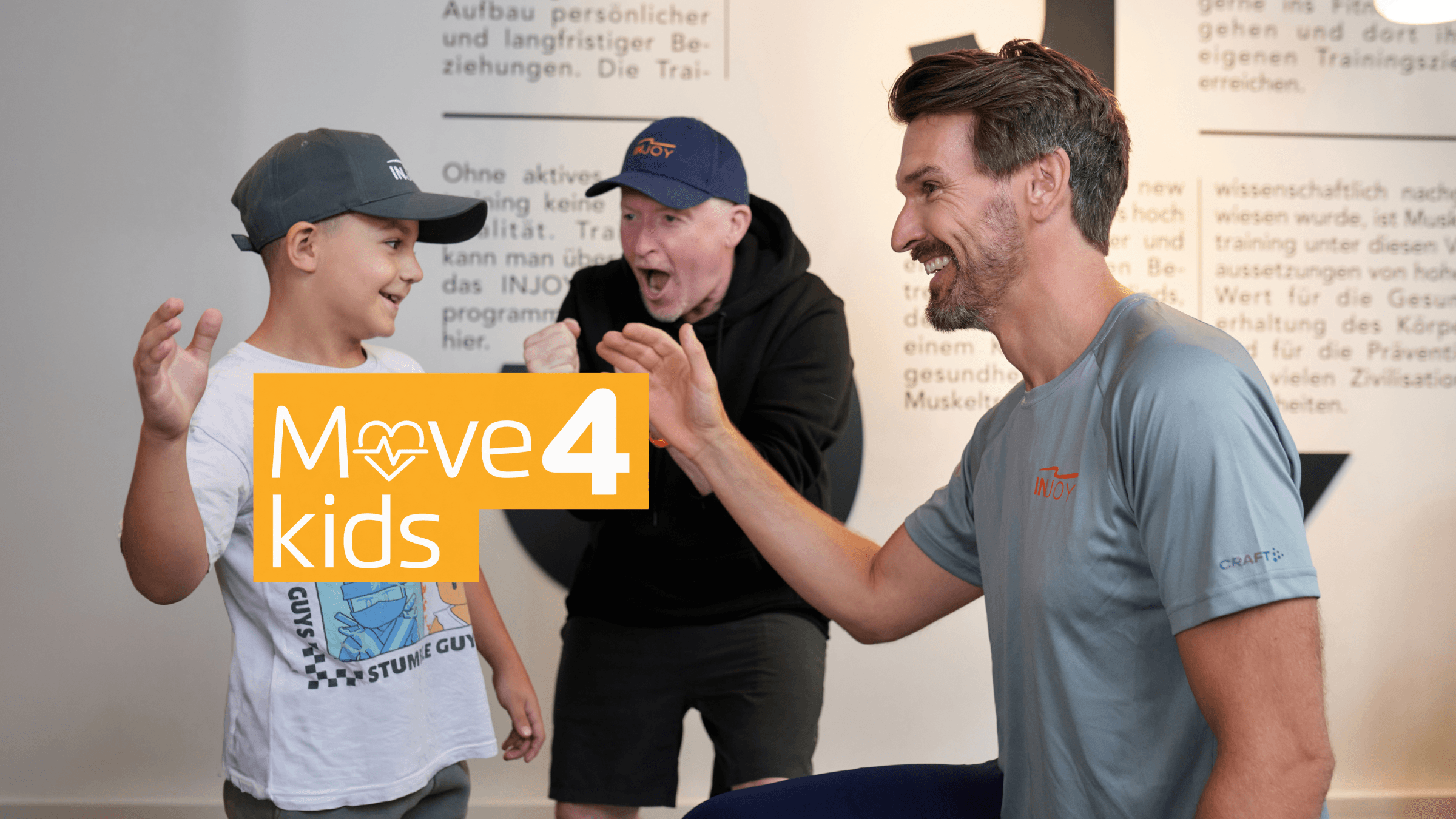 Ein Kind, Joey Kelly und ein Trainer klatschen ein. Darüber der Slogan "Move 4 kids".