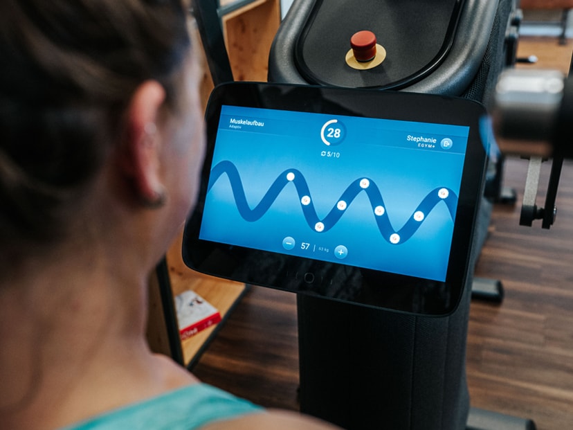 Eine Frau sitzt an einem eGym Trainingsgerät im INJOY Fitnessstudio Soest.