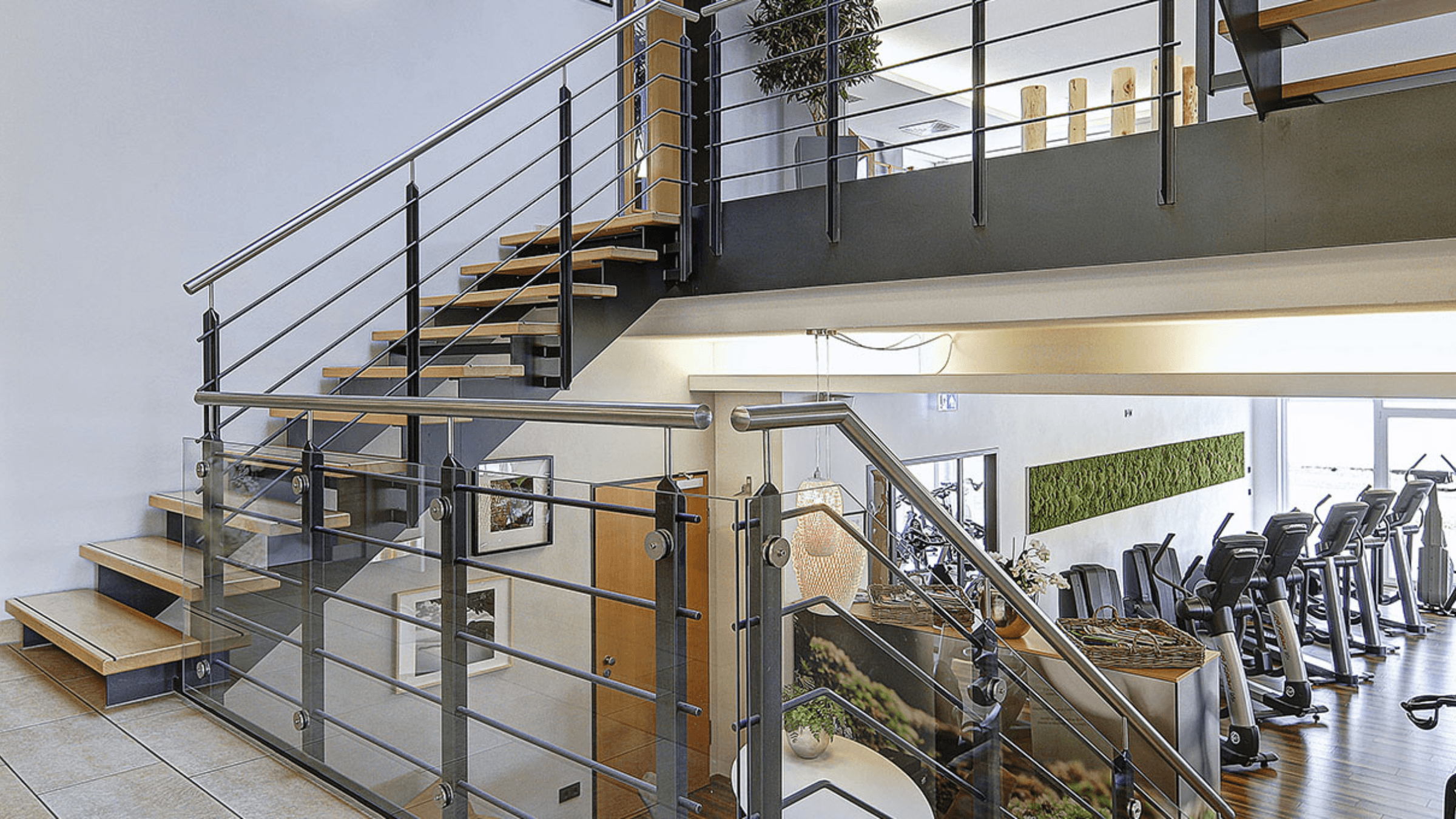 Innenansicht mit Treppen und Cardio-Geräten im INJOY Fitnessstudio Dettingen.