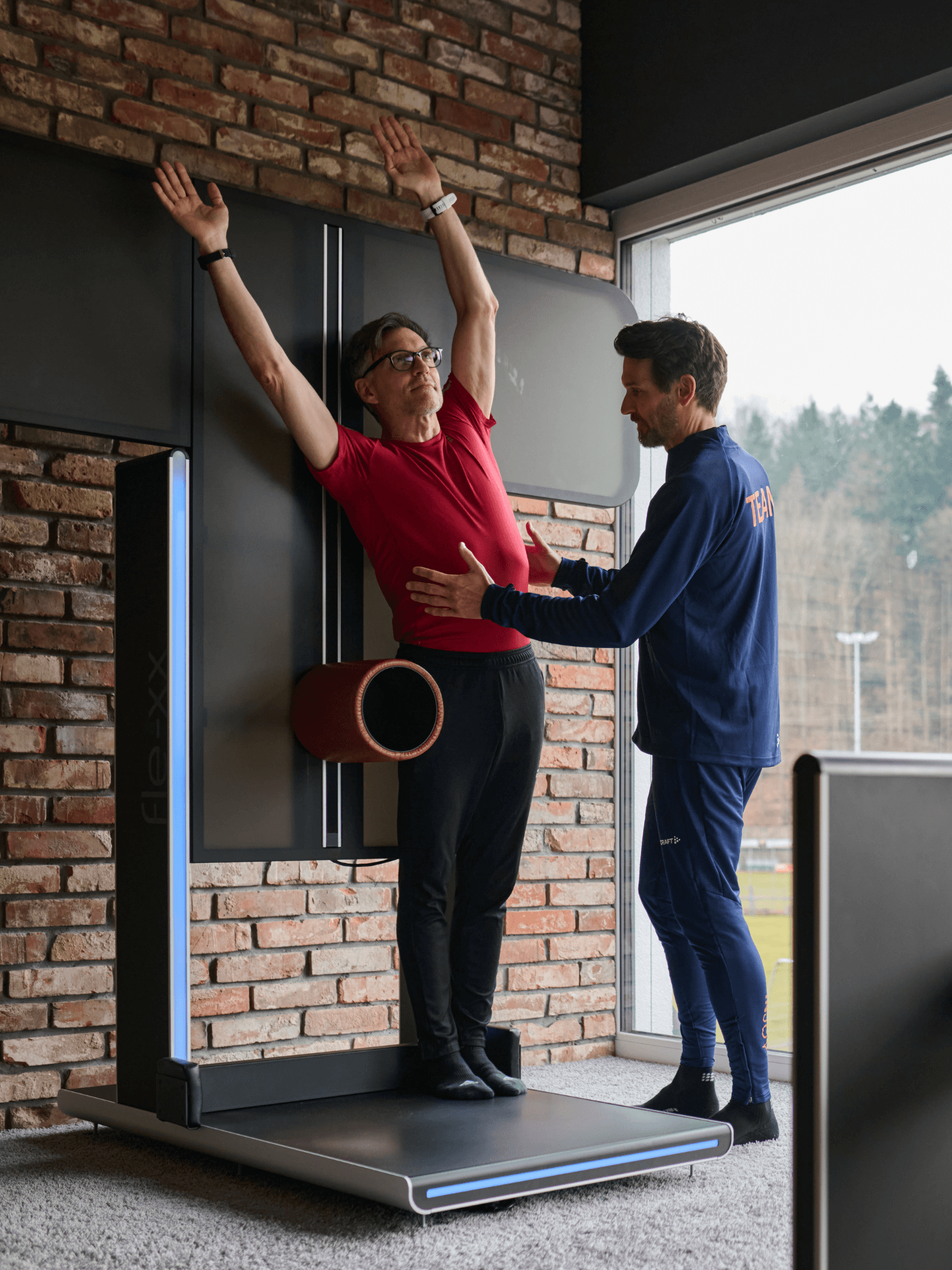 Ein männliches INJOY Mitglied bekommt von einem INJOY Trainer eine Einweisung für Rückenübungen.