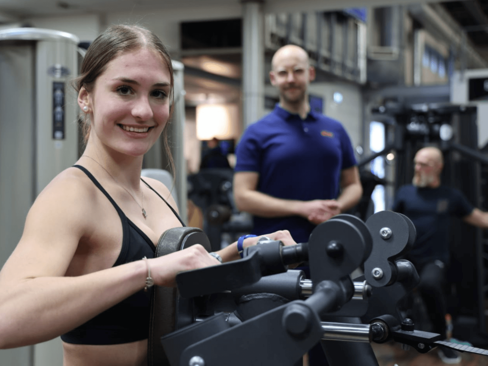 Eine lächelnde Frau an einem Trainingsgerät im INJOY Fitnessstudio Dorsten.